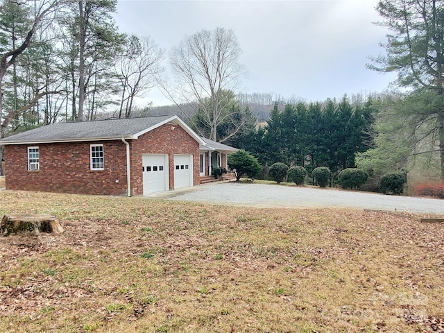 view of home's exterior featuring driveway, brick siding, and an attached garage