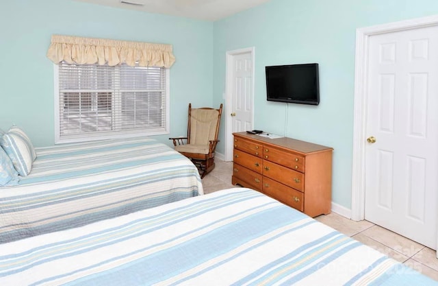 bedroom with light tile patterned floors, visible vents, and baseboards