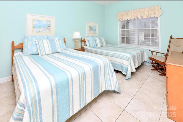 bedroom with light tile patterned flooring and baseboards