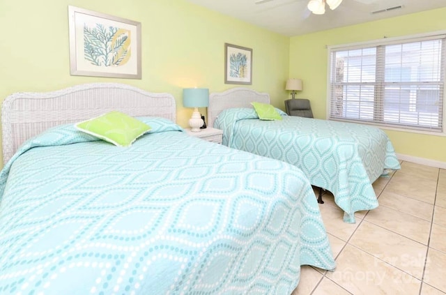 bedroom with tile patterned flooring, visible vents, ceiling fan, and baseboards