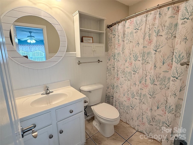 full bath featuring ceiling fan, toilet, a shower with shower curtain, tile patterned floors, and vanity