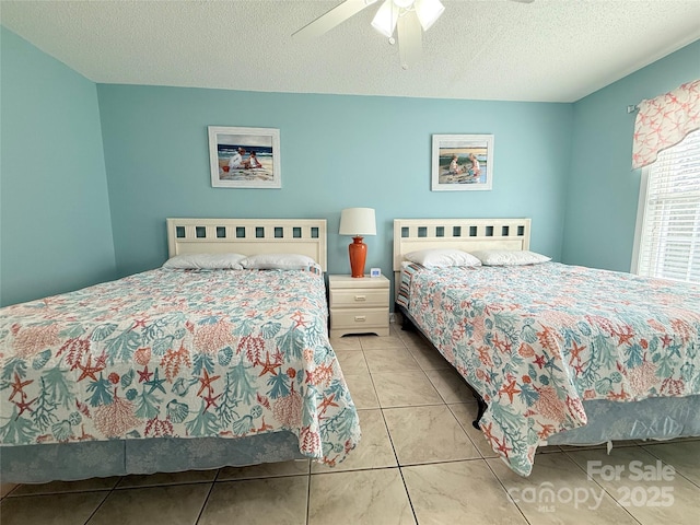 bedroom with tile patterned flooring, a textured ceiling, and a ceiling fan