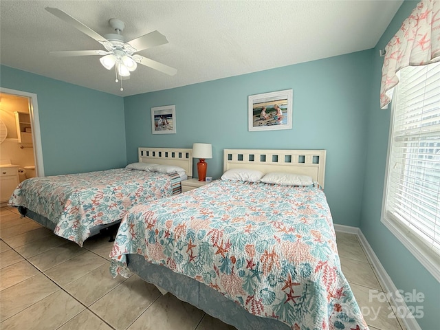 tiled bedroom featuring baseboards, a textured ceiling, and a ceiling fan