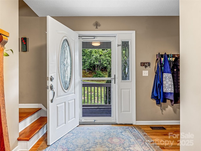 entryway featuring a wealth of natural light, visible vents, baseboards, and wood finished floors