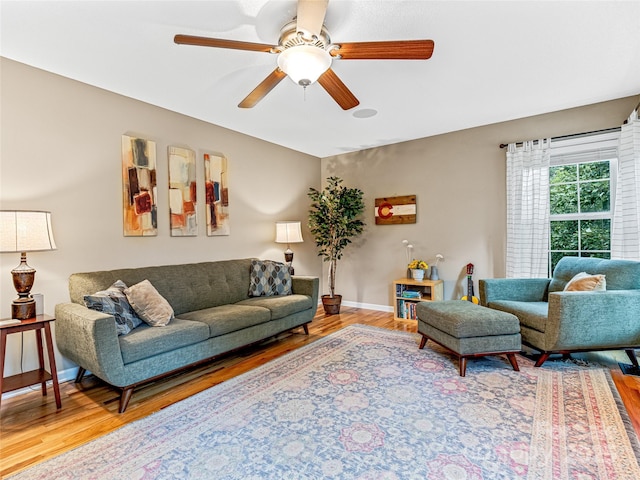 living room with baseboards, wood finished floors, and a ceiling fan