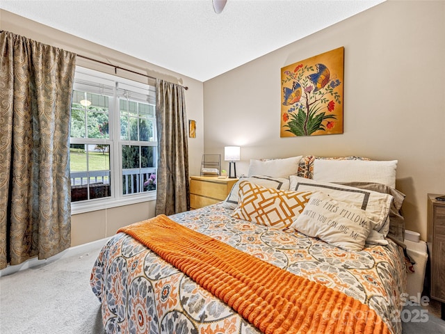 carpeted bedroom featuring a textured ceiling and a ceiling fan