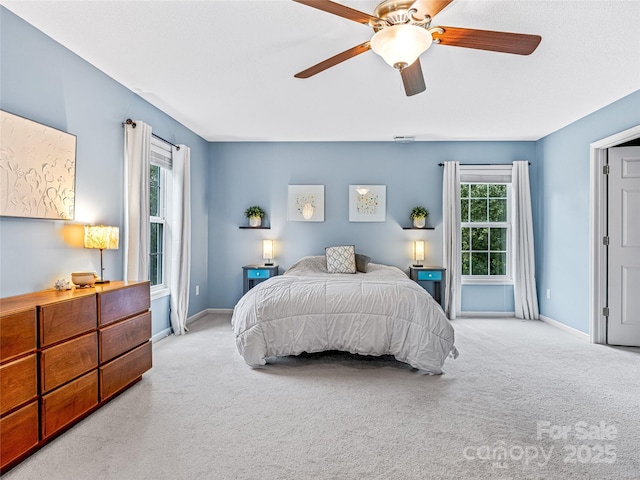 carpeted bedroom featuring baseboards and a ceiling fan