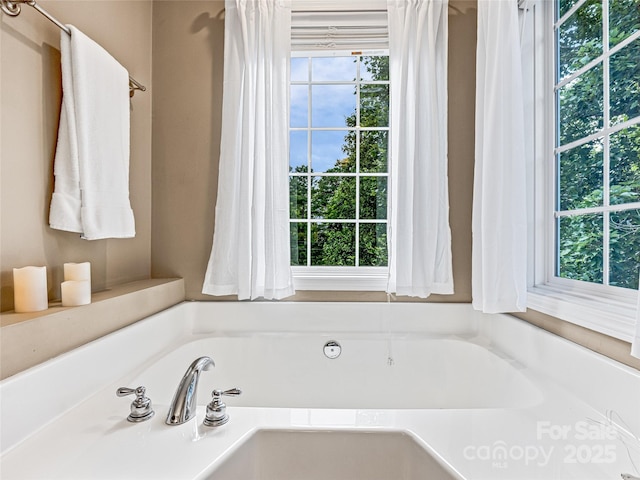 bathroom featuring a wealth of natural light and a bath