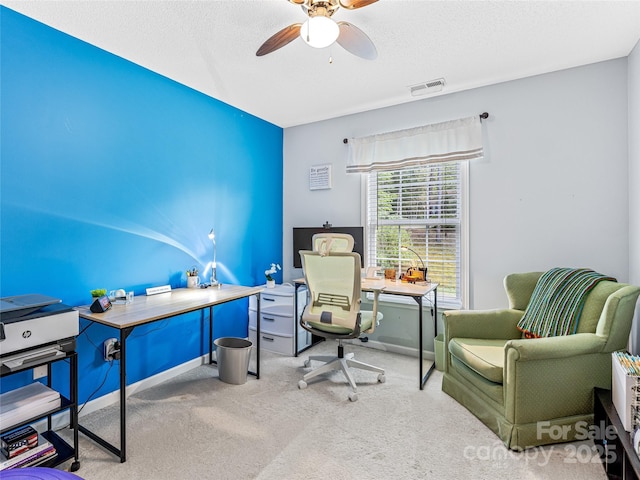 office area with carpet, a ceiling fan, visible vents, baseboards, and a textured ceiling