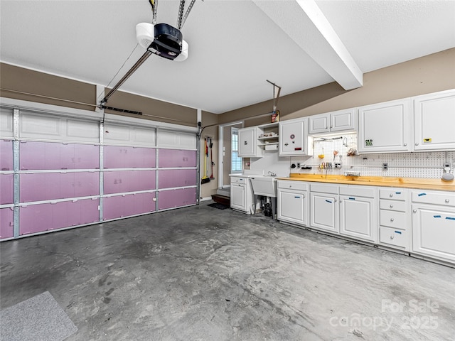 garage with a garage door opener and a sink