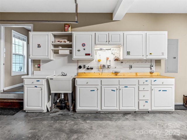 kitchen featuring concrete flooring, electric panel, decorative backsplash, white cabinetry, and open shelves