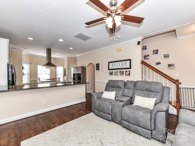 living room featuring arched walkways, visible vents, dark wood-type flooring, and ceiling fan