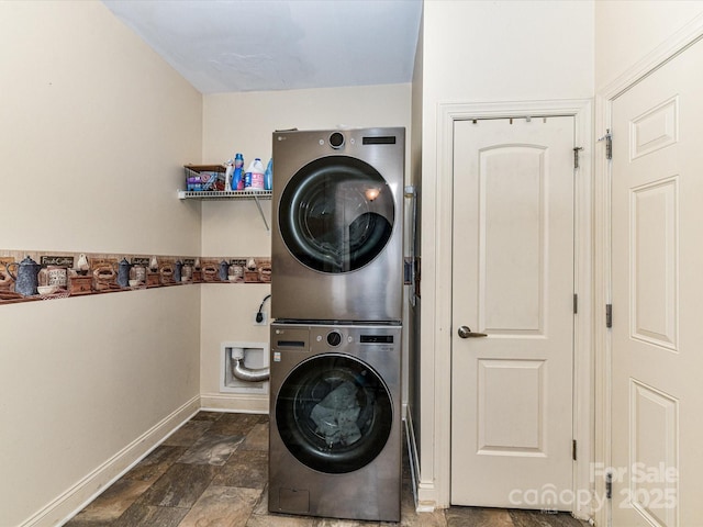 washroom with laundry area, baseboards, and stacked washer / drying machine