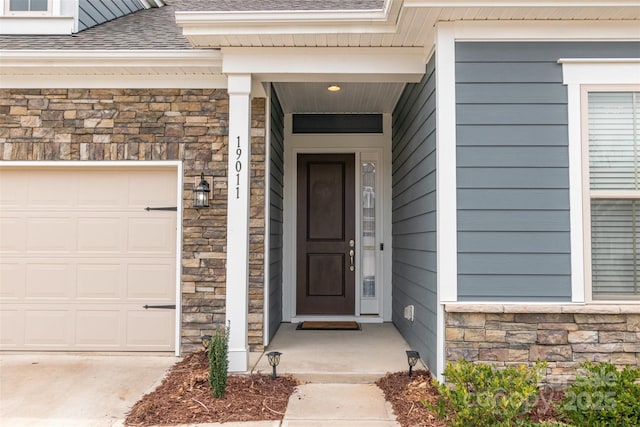 entrance to property featuring stone siding and a shingled roof