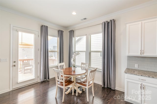 dining area with visible vents, baseboards, dark wood finished floors, and crown molding