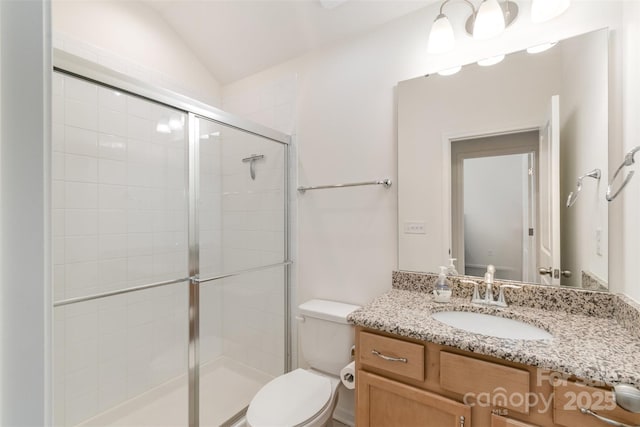 full bath featuring vanity, a shower stall, toilet, and vaulted ceiling