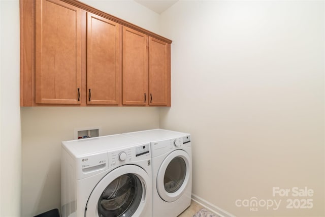 laundry area featuring cabinet space, independent washer and dryer, and baseboards