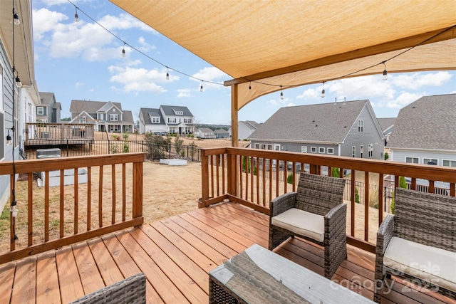 wooden terrace featuring a residential view and fence