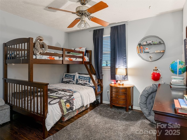 bedroom with ceiling fan, a textured ceiling, baseboards, and wood finished floors