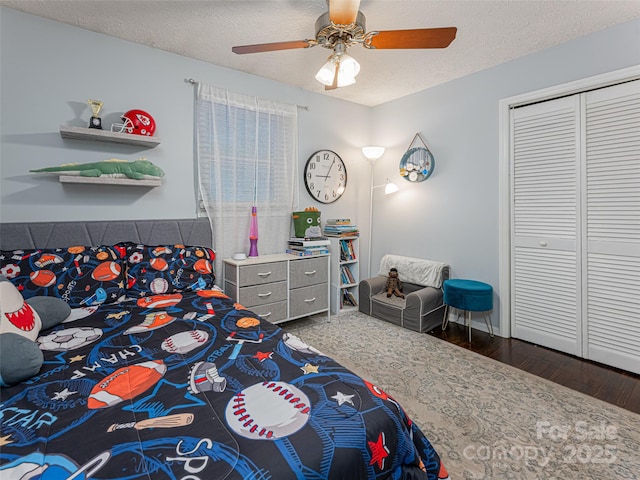 bedroom featuring a closet, a textured ceiling, ceiling fan, and wood finished floors