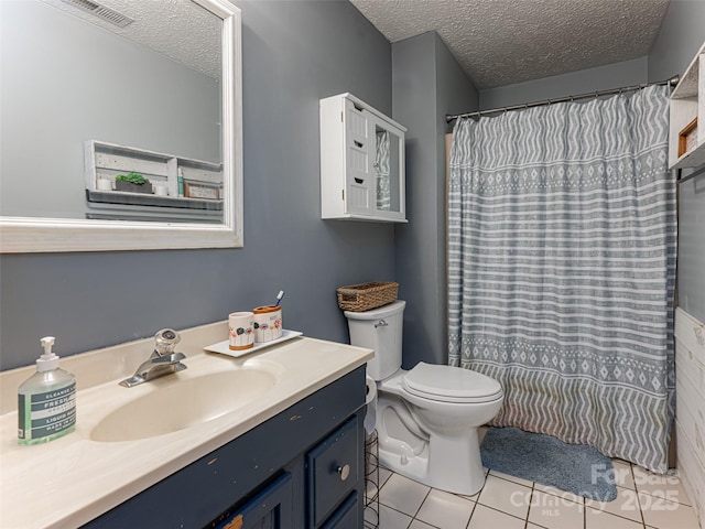 full bath with tile patterned flooring, toilet, a textured ceiling, and vanity