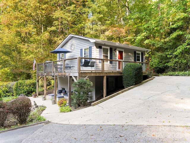 view of front facade with a patio area, driveway, and a deck