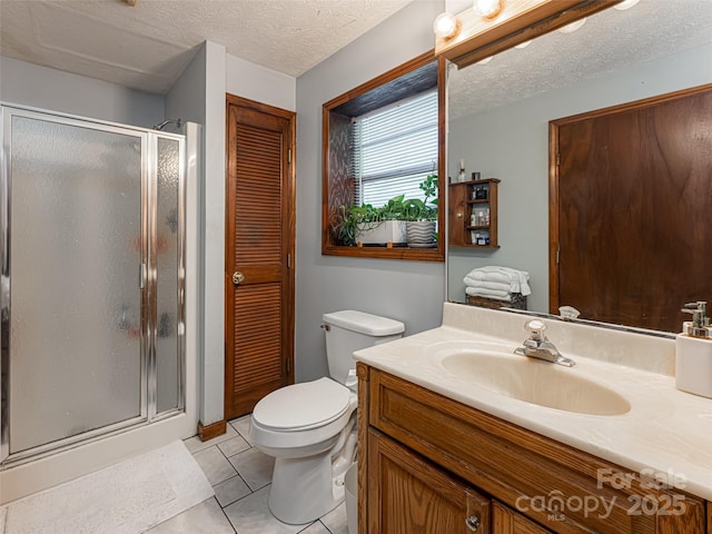 bathroom featuring a shower stall, toilet, vanity, tile patterned floors, and a textured ceiling