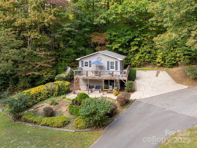 view of front of property with central air condition unit, a patio area, driveway, and a wooden deck