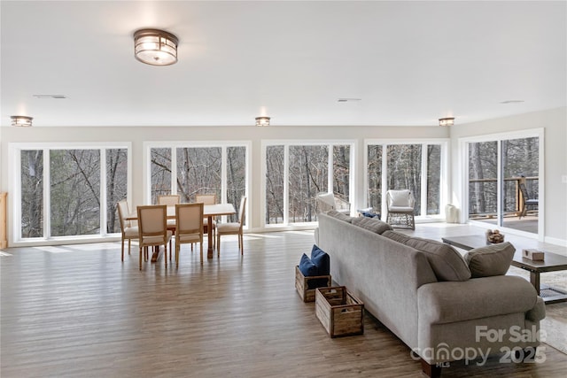 living room featuring visible vents, a healthy amount of sunlight, and wood finished floors