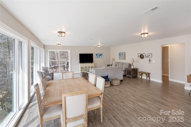 dining space featuring wood finished floors, visible vents, and baseboards