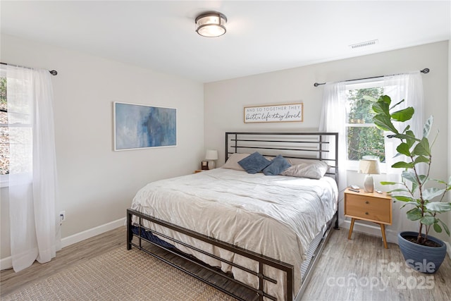 bedroom featuring visible vents, baseboards, and light wood-style floors