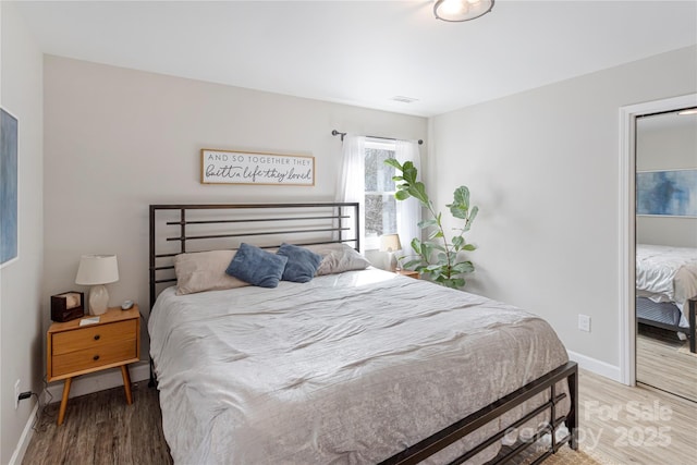 bedroom with baseboards and wood finished floors