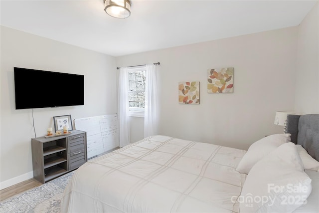 bedroom with baseboards and wood finished floors