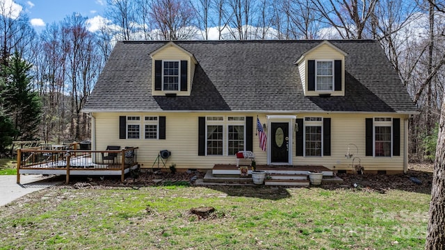 cape cod home with a shingled roof, a front lawn, a wooden deck, and crawl space