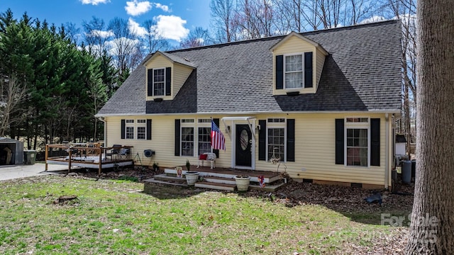 new england style home with crawl space, a wooden deck, a front yard, and a shingled roof