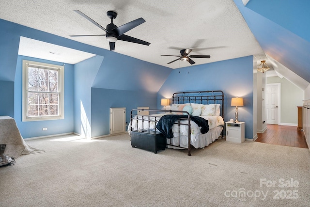 bedroom with lofted ceiling, carpet, and a textured ceiling