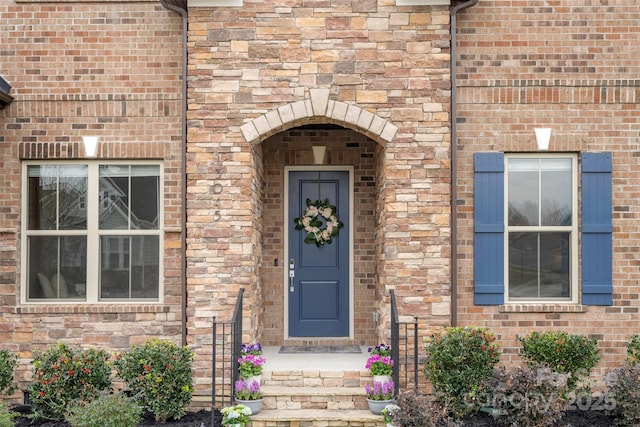 property entrance with brick siding and stone siding