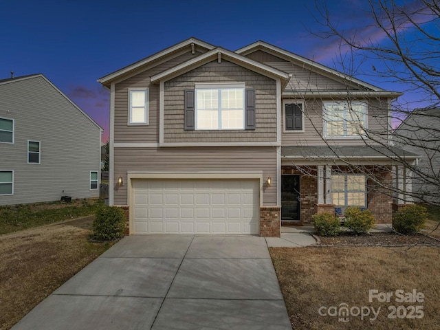 view of front of house with brick siding, an attached garage, covered porch, and driveway