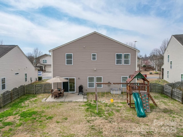 back of property featuring a playground, a patio area, a lawn, and a fenced backyard