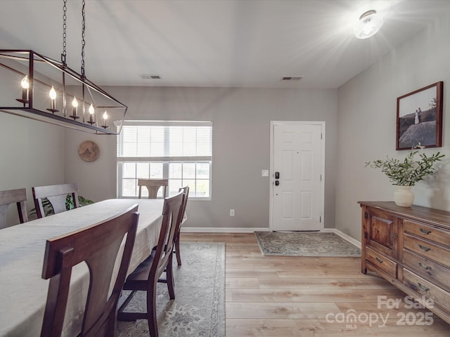 dining room with visible vents, baseboards, an inviting chandelier, and light wood-style flooring