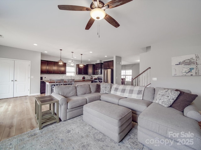 living room featuring visible vents, light wood-style flooring, recessed lighting, baseboards, and ceiling fan