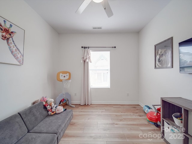 rec room with visible vents, light wood-style flooring, baseboards, and ceiling fan