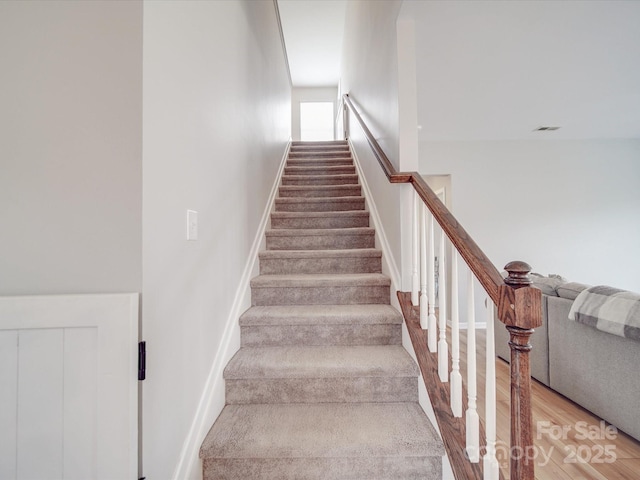 stairs featuring wood finished floors and visible vents