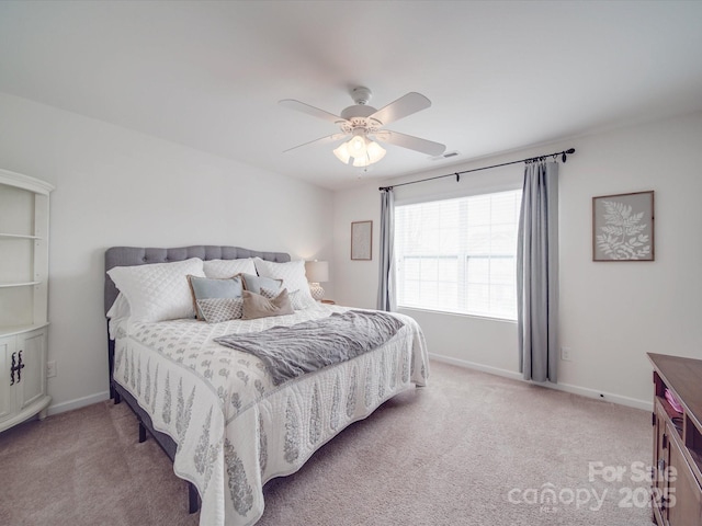 bedroom featuring visible vents, light colored carpet, baseboards, and ceiling fan