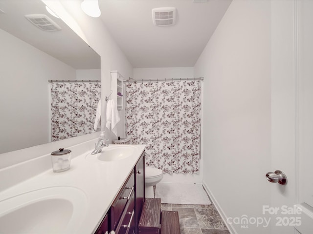 full bathroom with a sink, visible vents, toilet, and double vanity