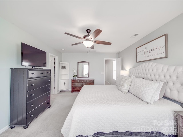 bedroom featuring visible vents, light colored carpet, and a ceiling fan