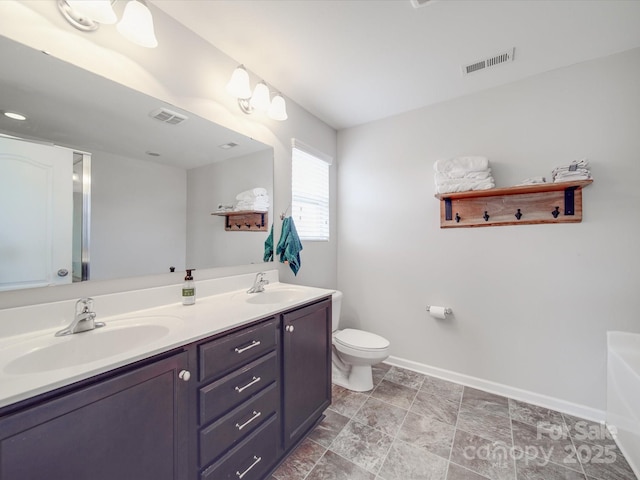 full bath featuring a sink, baseboards, toilet, and double vanity