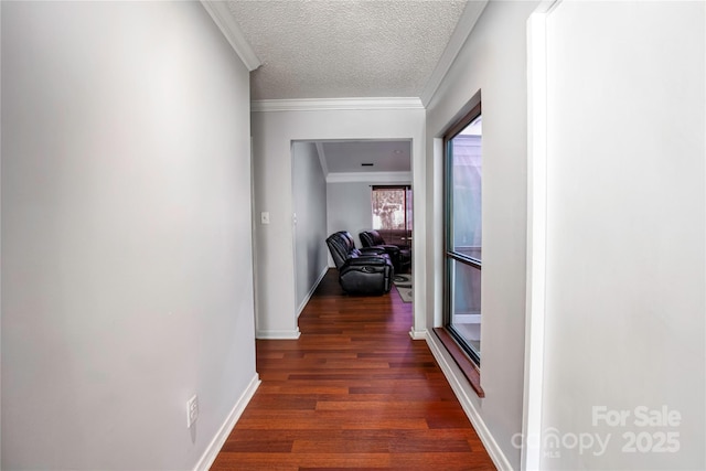 corridor featuring dark wood finished floors, a textured ceiling, crown molding, and baseboards