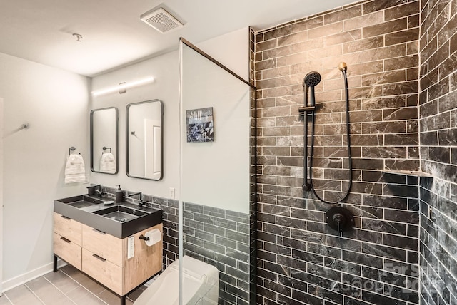 full bathroom featuring tile patterned floors, visible vents, tile walls, tiled shower, and vanity