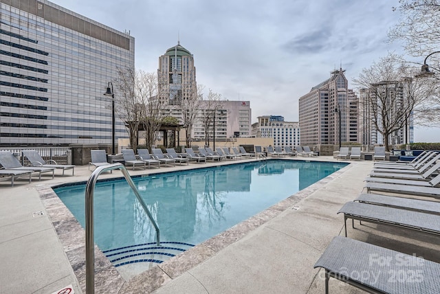 pool featuring a view of city and a patio area